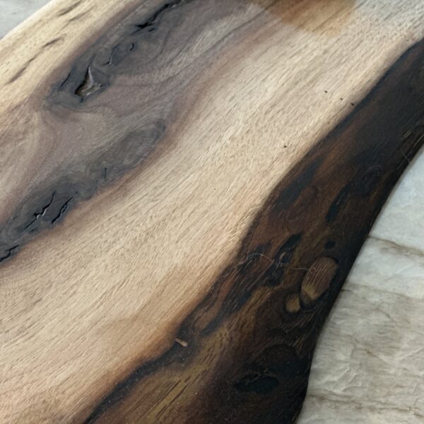 Handcrafted live edge charcuterie board with dark and light grain and an elegant shape
